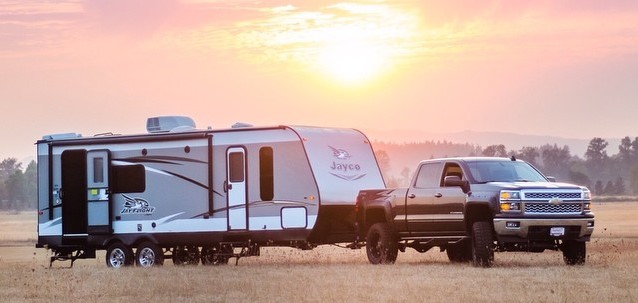 Photo of truck and RV in sunset.