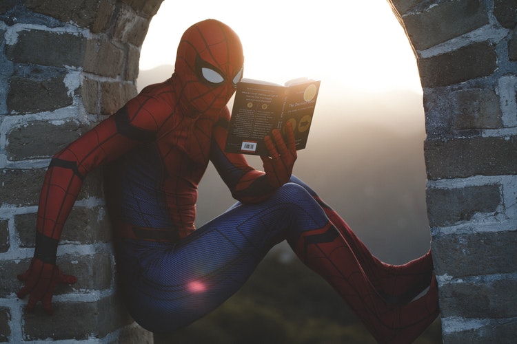 Photo of superhero reading a book.