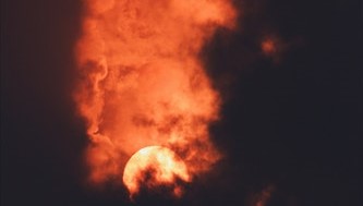 Photo of smoke over red moon.