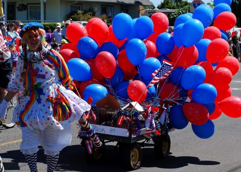 Photo of clown with RW&B balloons in parade.