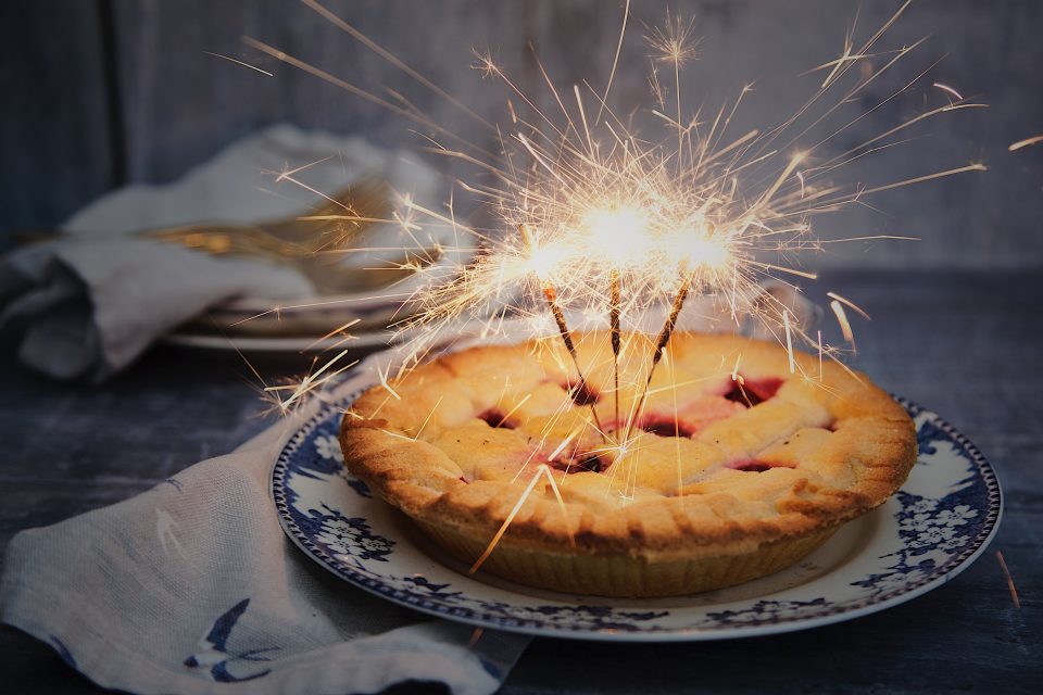 Photo montage of a berry pie with sparklers to celebrate Independence Day