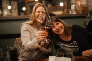 Photo of two women drinking wine and laughing at Sybaris Bistro in Albany Oregon