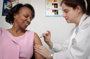 Image of nurse giving a female patient an influenza vaccine