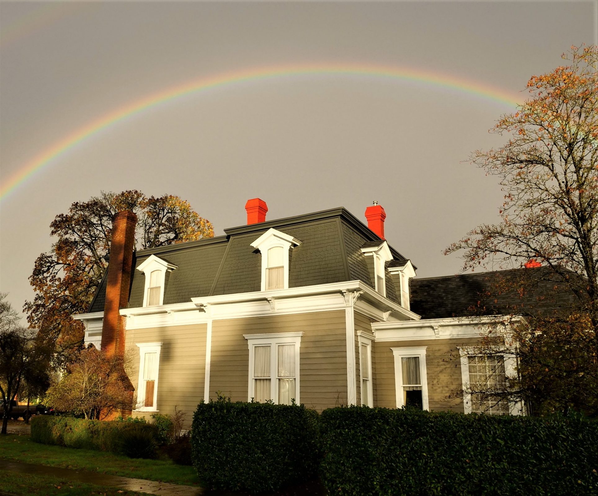 photo of rainbow over histotic home in Albany, Or by Camron Settlemier