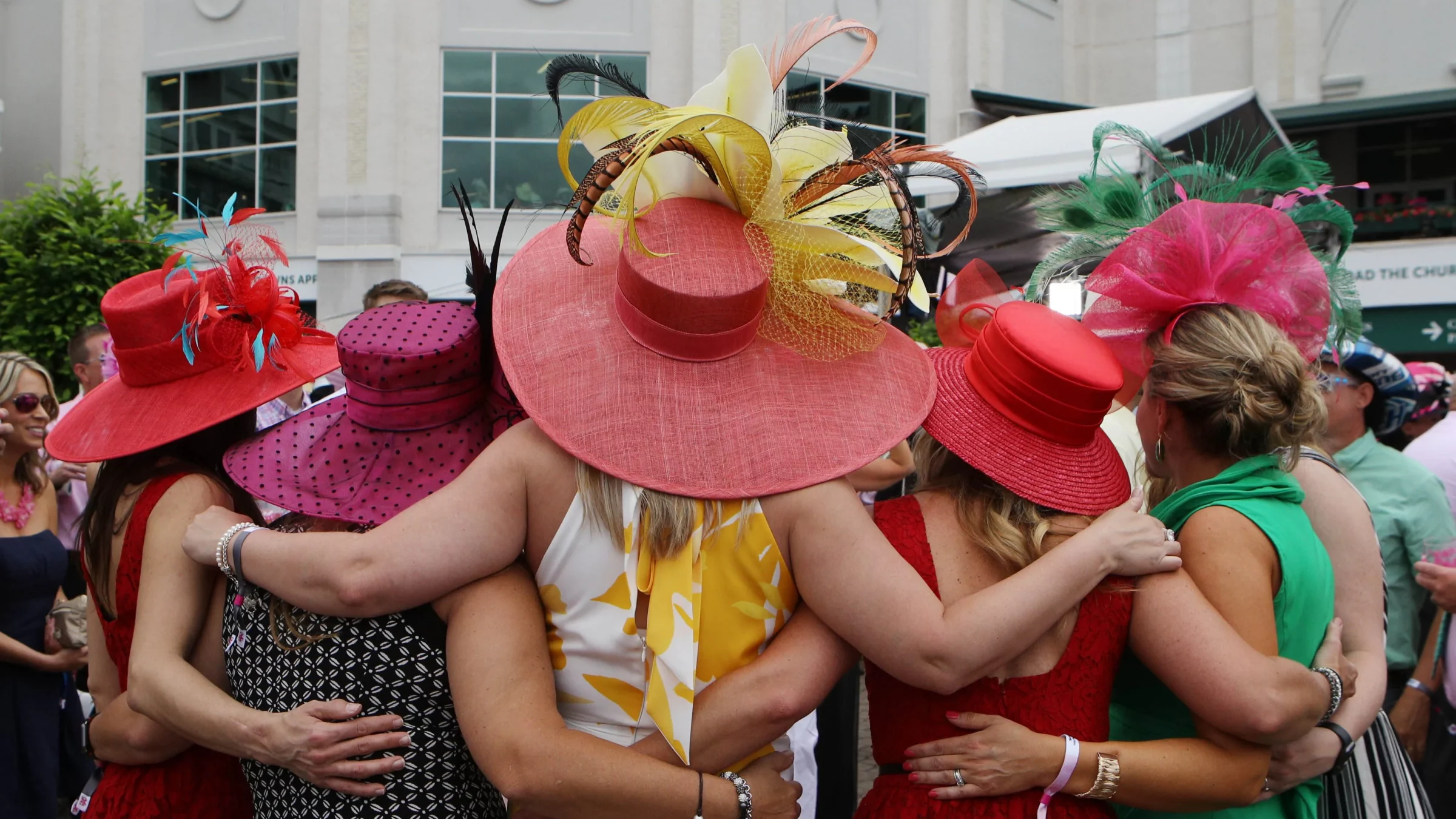 woman wearing colorful elaborate hats taken from the back