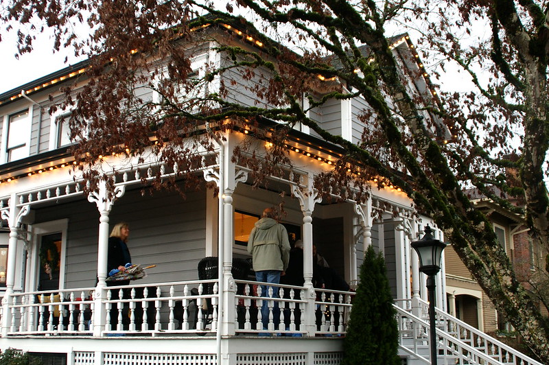 Visitors on a wrap around porch of a historic home