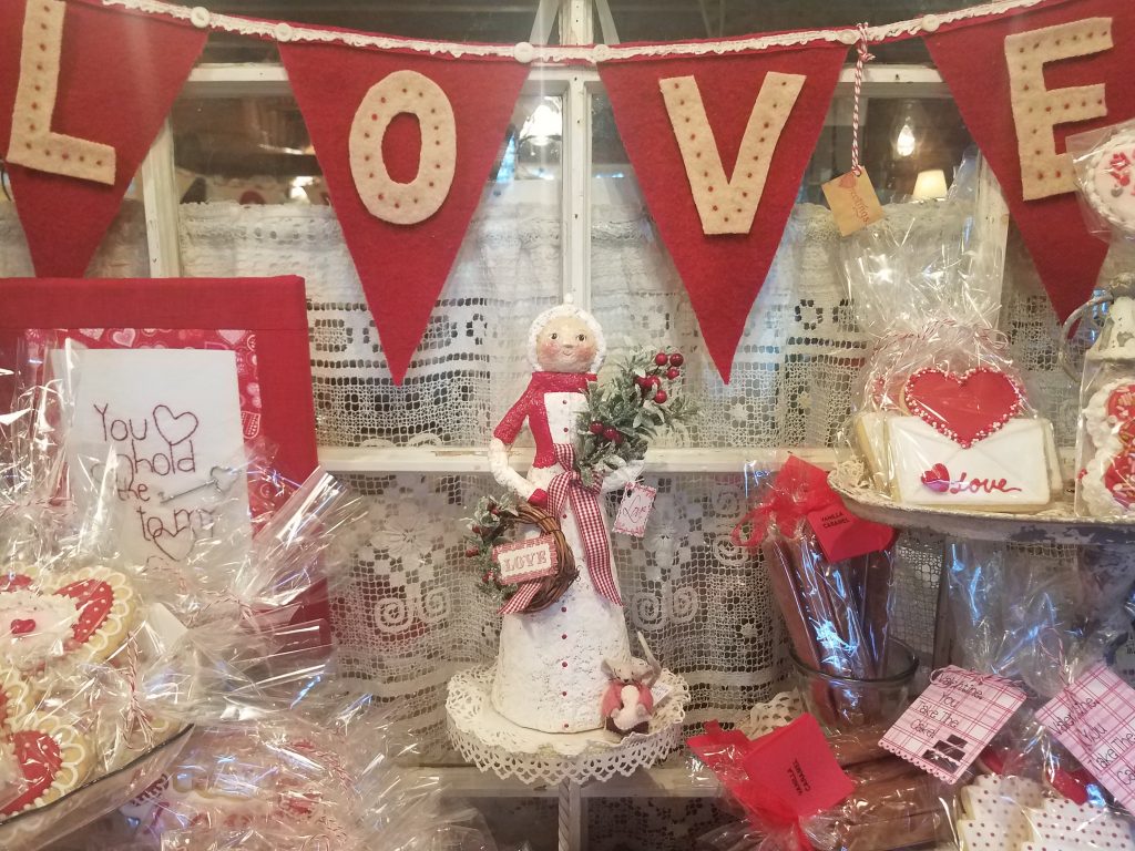 LOVE banner above a table covered in Valentine's knick-knacks