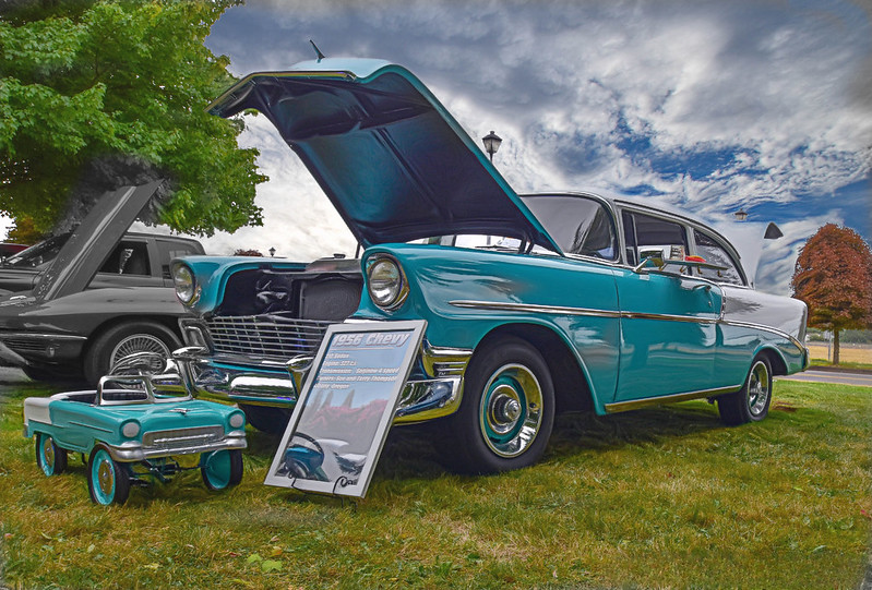 a classic car painted teal with a matching pedal car in front